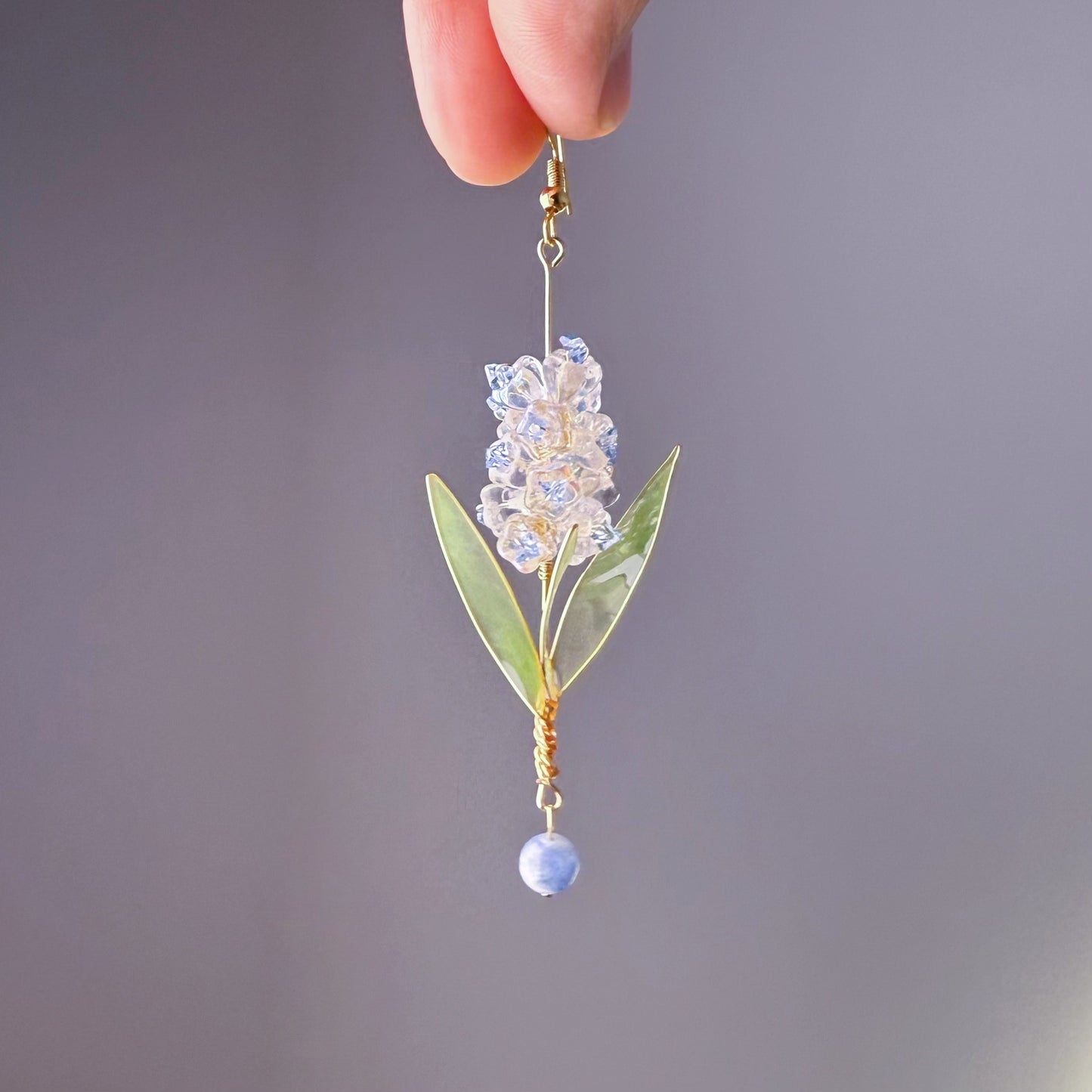 Handmade earrings with floral design on a gray background